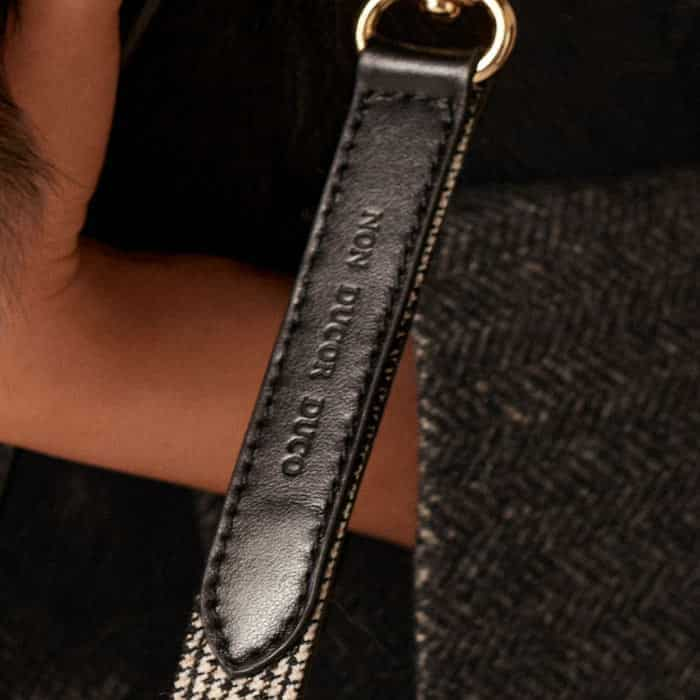 This features 100% Italian leather detailing with mini houndstooth tailoring that matches key pieces in the collection.