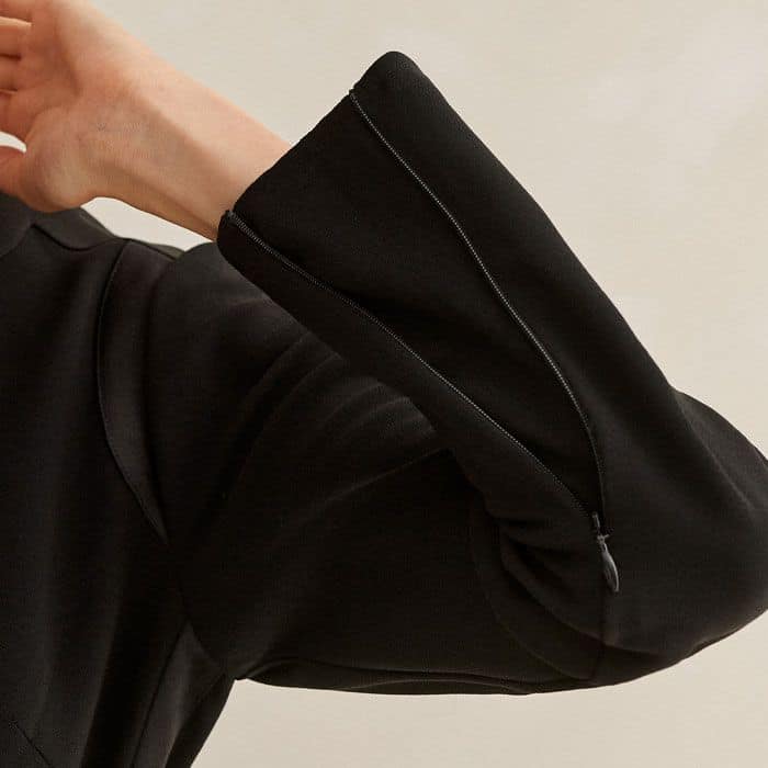 The zipped cuffs switch from a more fitted to a flared silhouette through the ends of the long sleeves.