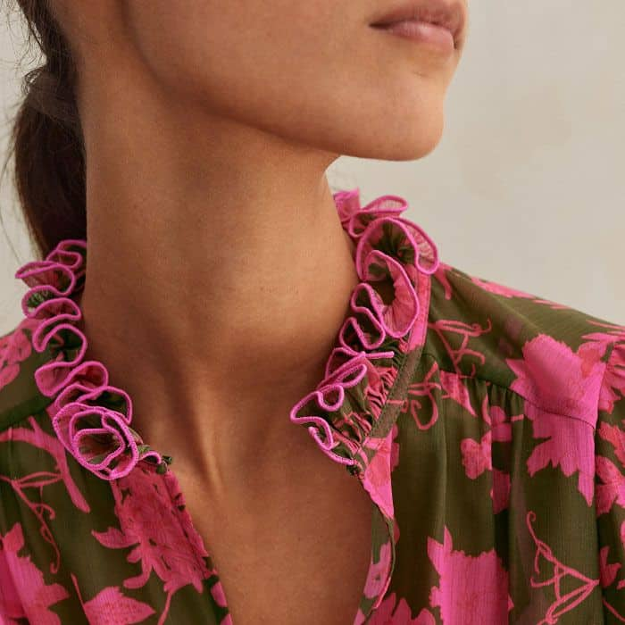 With a hook-and-eye fastening, the neckline switches from a round one with a keyhole detail to a V-shaped one.