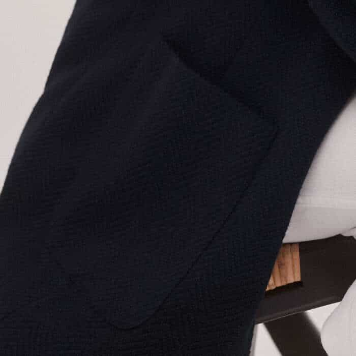 Functional pockets are positioned either side of the single-breasted front to accomodate small essentials.