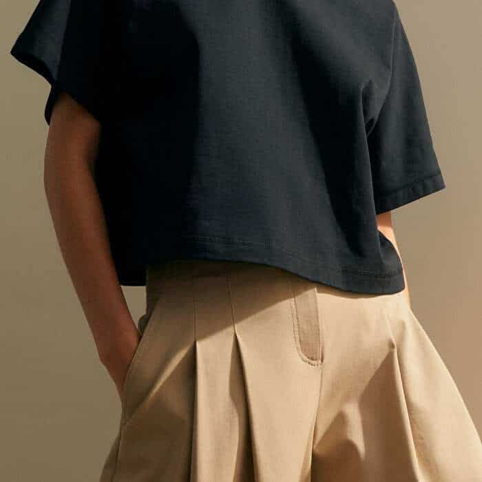 The cropped length allows the belts of high-waisted trousers to be left on display.