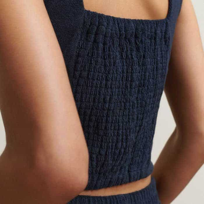 A smocked panel at the back of the piece provides additional stretch to accommodate different bust sizes.