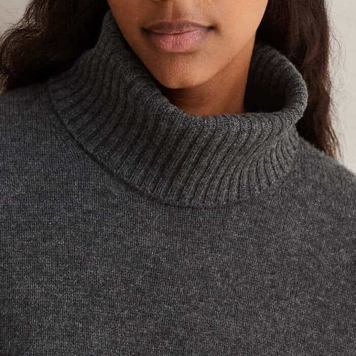 Securing with a series of concealed buttons, the detachable snood switches the silhouette from a round to a high-neck silhouette.