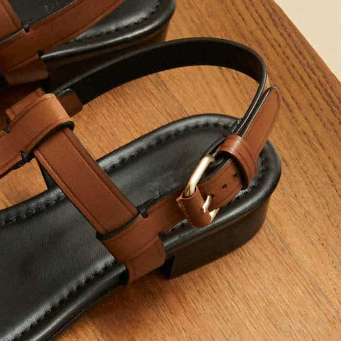 The adjustable buckle is made from gold-toned hardware and features a leather-covered roller buckle.