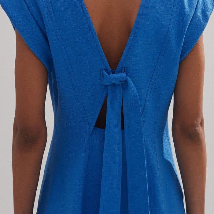 A tie detail at the back of the piece allows you to create a more structured silhouette.