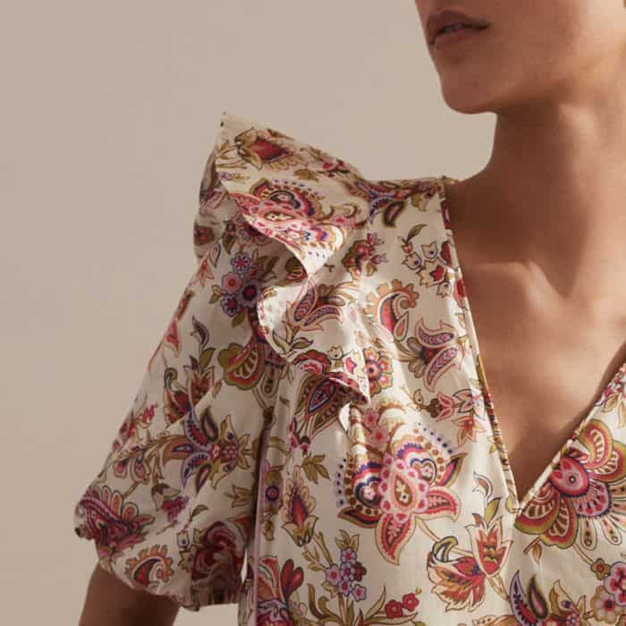 The shoulders are granted a feminine finish with a ruffled trim.