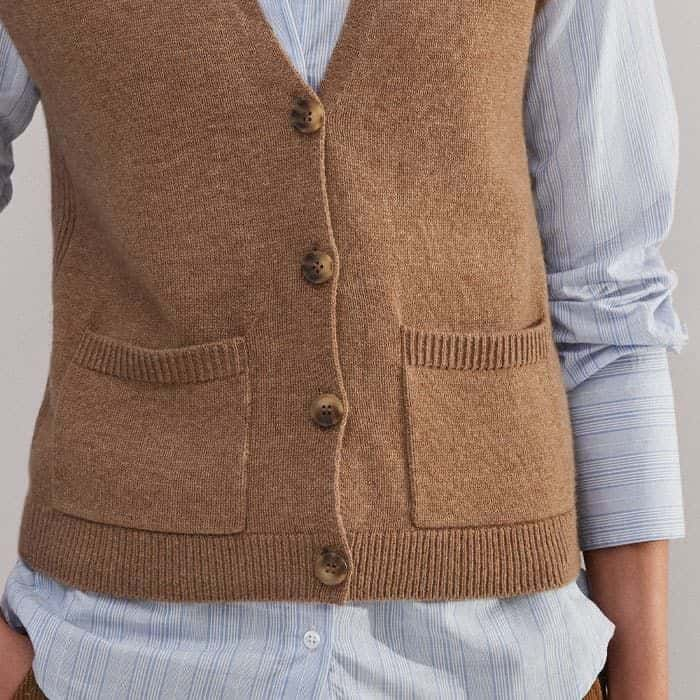 Pockets on either side of the button-down front add functionality to the piece.