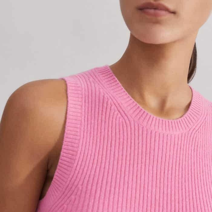 The neckline and armholes are outlined with a vertical ribbed trim to maintain the shape of the piece.