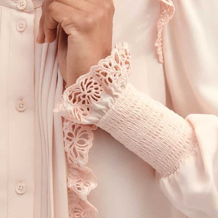 The balloon sleeves fall to deep-shirred cuffs with a lace trim for a feminine finish.