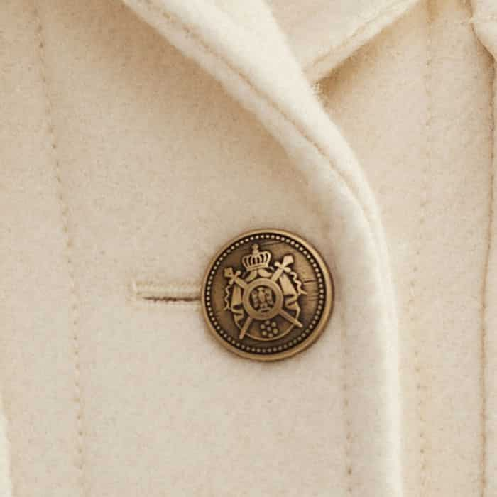 Ornate, bronze-toned buttons put a luxe spin on traditional military styling.