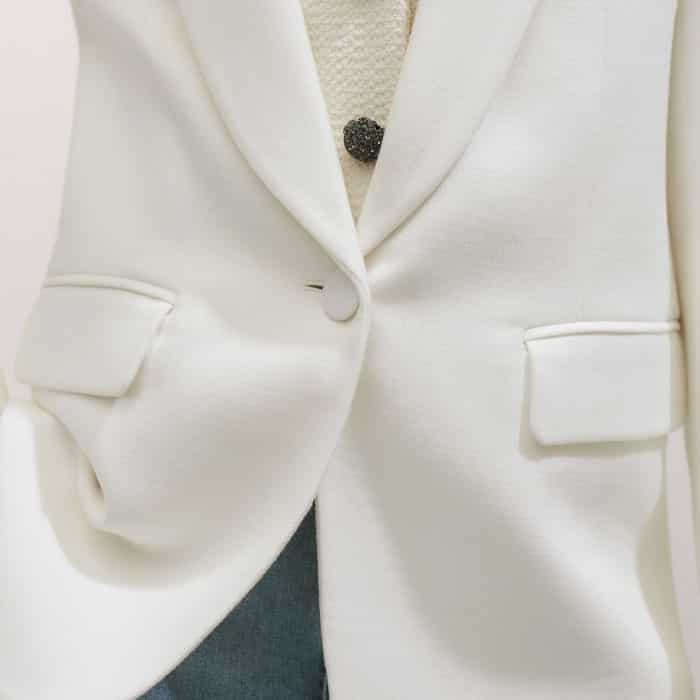 Topped with flaps, pockets are positioned on either side of the button-down front.