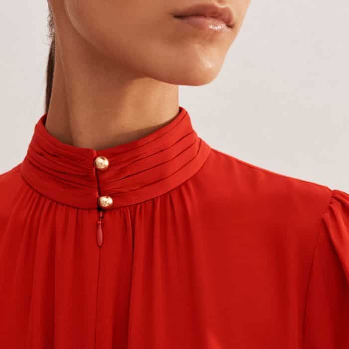 The buttoned neckline allows for the choice of a high-neck, keyhole look or an open V.