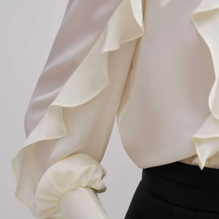 This piece is elevated with ruffled detailing for a feminine finish.