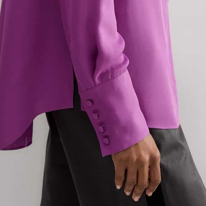 The long sleeves fall to deep cuffs which are lined with buttons.