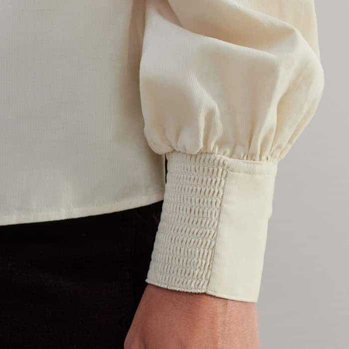 The cuffs are shirred on one side to keep the front free from detailing.