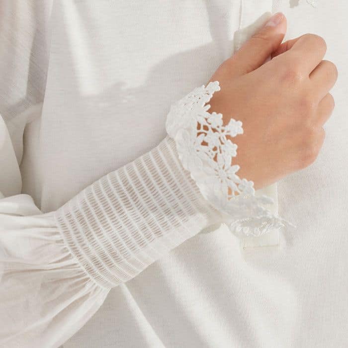 The sleeves fall to smocked cuffs to introduce flattering volume through the sleeves.