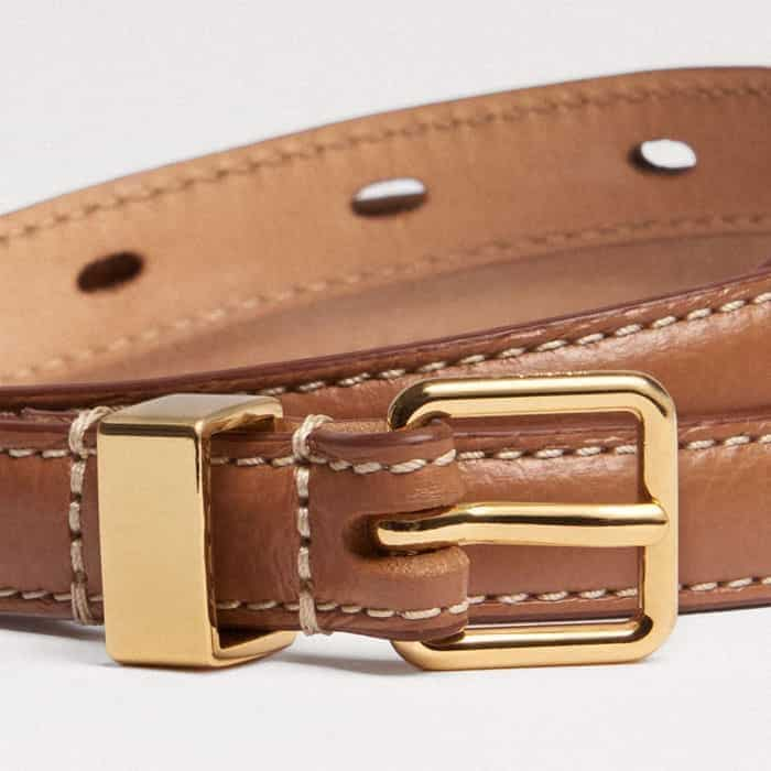 Introducing a gilded finish, the buckle and keeper are rendered in gold-plated hardware.