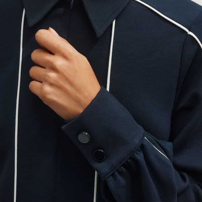 The cuffs are equipped with two snap buttons which can be undone to turn back the sleeves.