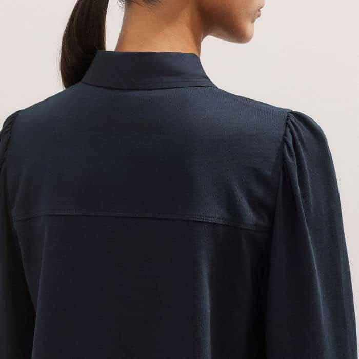 A small pouf at the shoulders introduces flattering volume through the sleeves.