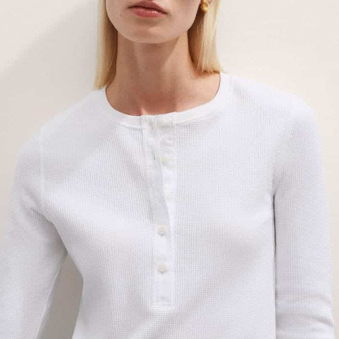 The half-button placket features a contrasting woven panel for a polished finish.