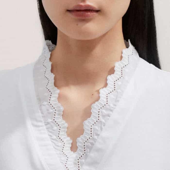 The neckline and cuffs are signed off with an embroidered lace trim for a feminine finish.