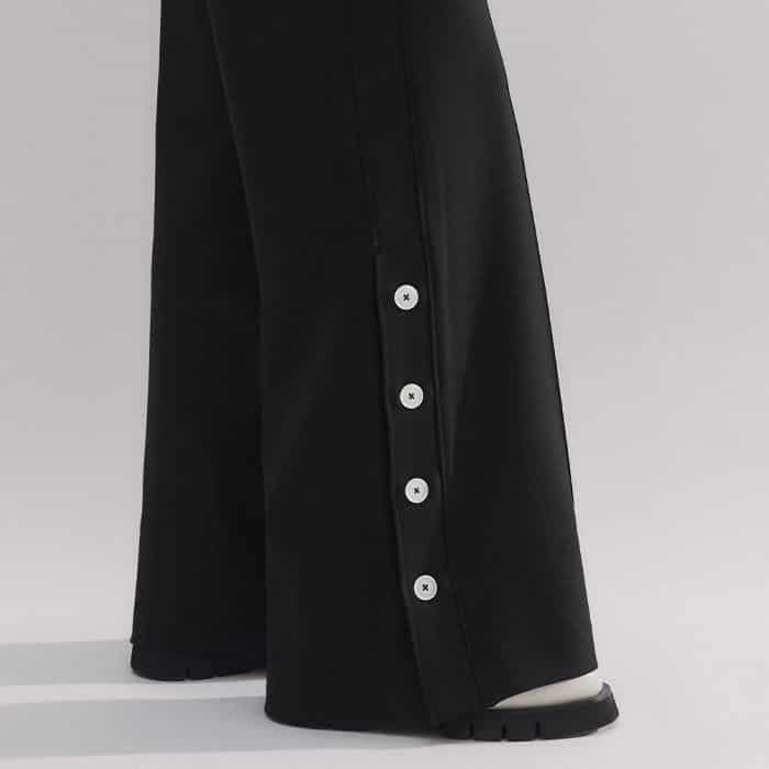 The contrasting white buttons at the hem can be undone to change the final silhouette of the leg.