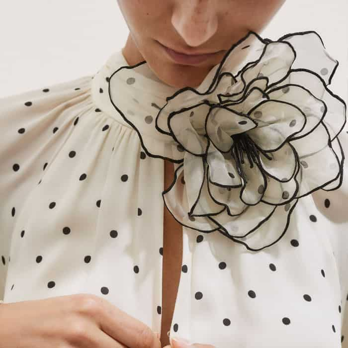 Add a floral detail to the neckline of the piece with the detachable corsage.