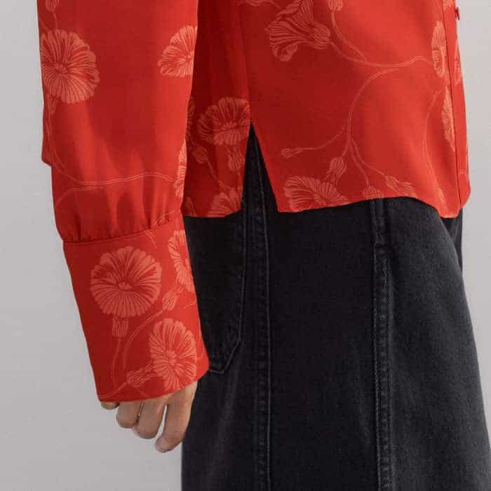 The cuffs are lined with four buttons in the same orange hue to turn-back sleeves.