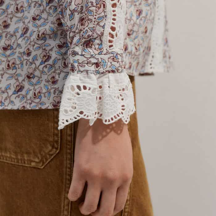 The deep cuffs are signed off with a lace trim that peeks out of sleeves when the piece is layered.