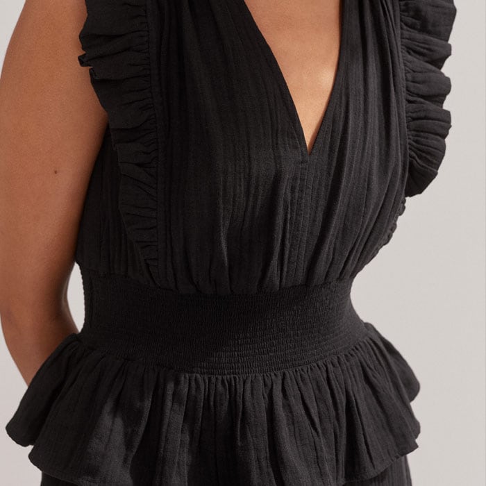 Ruffles make their way around the armholes and waistband for a flattering finish.