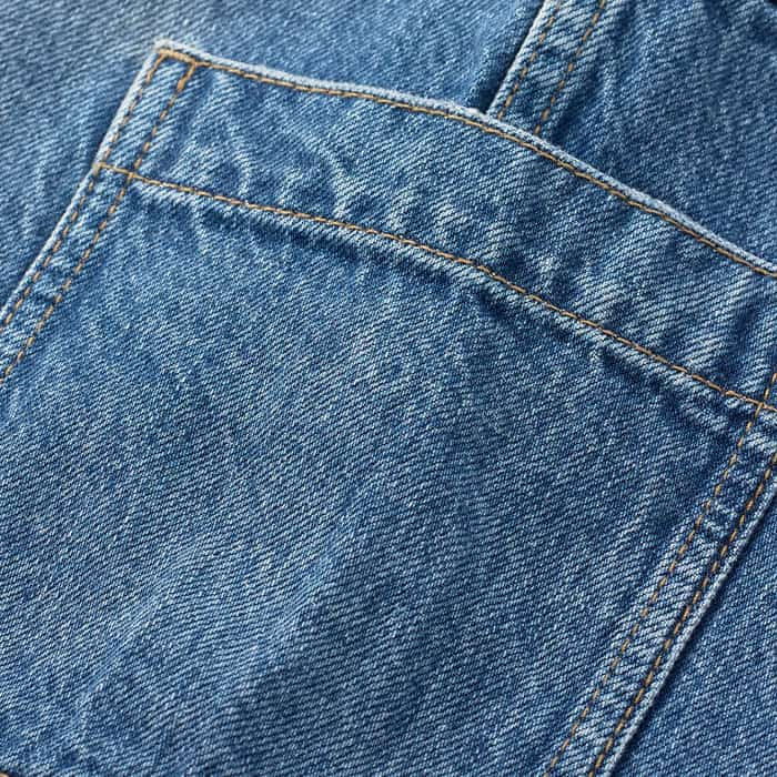 Cotton denim, which is washed to give highs and lows in the mid-blue colour.