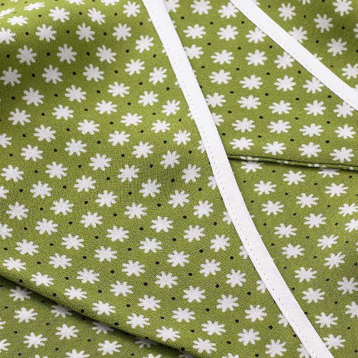 Crafted from silk, this fabric has a super soft hand feel and features our bespoke Daisy flower print, combining olive and cream hues.