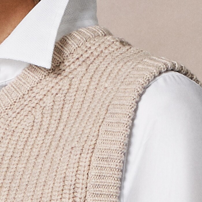 With a detachable snood, this sleeveless knit sits comfortably over a shirt or under a blazer. 