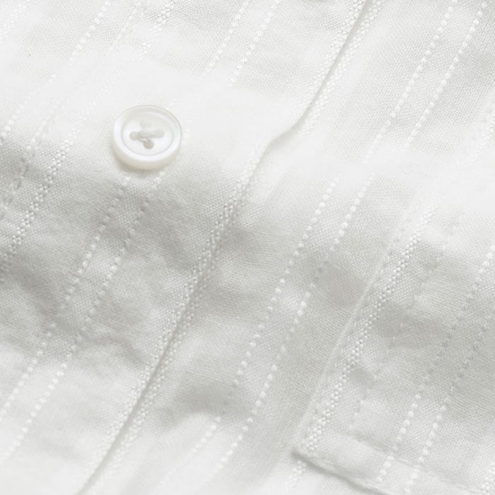 Lightweight and breathable, this cotton blend fabric features a simple stripe design in a tonal white hue that adds depth to your warm-weather wardrobe. 