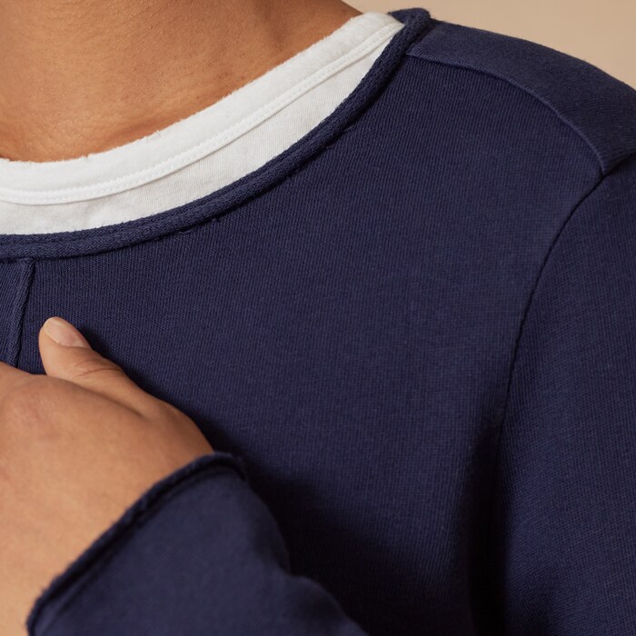 A raw edge trim on the cuffs, hem and neckline of the sweatshirt provide a cool edge.