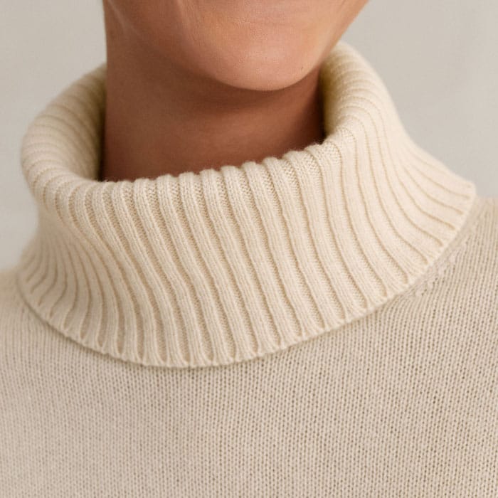 Create a high-neck silhouette by attaching the snood that secures with a series of concealed buttons on the round neckline.